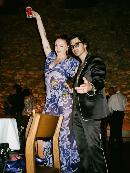 Di sebuah perayaan, Sophie Turner dan Joe Jonas kembali tampil mesra. Sophie tampil chic dalam balutan dress transparan berwarna biru dan bermotif floral, sedangkan Joe dengan all black outfit. [Foto: Instagram/sophiet]