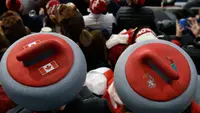 Penonton mengenakan atribut kepala unik saat menyaksikan cabang curling ganda campuran antara Kanada dan Swiss pada Olimpiade Musim Dingin 2018 di Gangneung, Korsel, Selasa (13/2). Olimpiade ini berlangsung hingga 25 Februari mendatang. (AP/Aaron Favila)