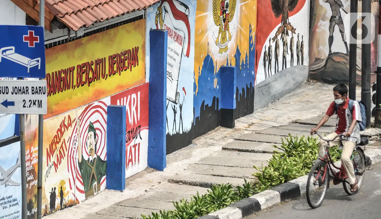 Pengendara sepeda melintas di depan mural bertemakan Pancasila di Kampung Pancasila kawasan Galur, Johar Baru, Jakarta, Selasa (1/6/2021). Kelurahan Galur membuat Kampung Pancasila yang dihiasi mural sebagai bentuk mengingatkan masyarakat akan Pancasila sebagai dasar negara. (merdeka.com/Iqbal S. Nu