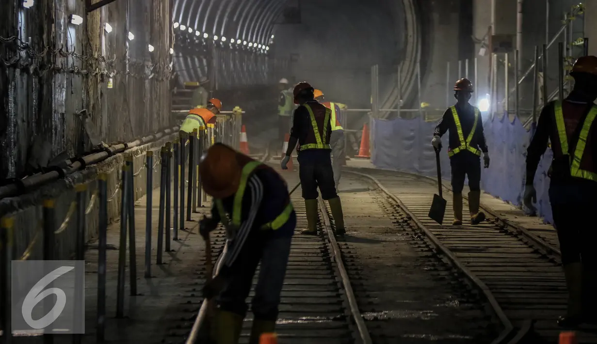 Para pekerja membersihkan jalur rel di terowongan Mass Rapid Transit (MRT) di Dukuh Atas, Jakarta, Jumat (30/9). Jumlah stasiun yang dilalui di rute tersebut sebanyak 13 stasiun. (Liputan6.com/Faizal Fanani)