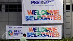 Pekerja melintas di depan baliho dan spanduk ucapan PSSI di depan Hotel Mercure Ancol Jakarta, Rabu (9/11). Kongres PSSI 2016 akan memilih Ketua dan Wakul Ketua serta anggota Komite Ekssekuitf. (Liputan6.com/Helmi Fithriansyah)