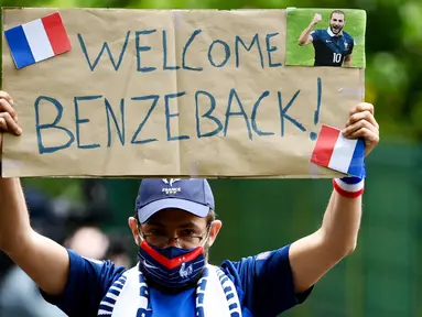 Fans menunjukan poster selamat datang kepada Karim Benzema saat sesi latihan Timnas Prancis di Clairefontaine-en-Yvelines, Rabu (26/5/2021). Benzema kembali memperkuat Timnas Prancis setelah enam tahun absen. (AFP/Franck FIfe)