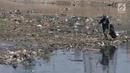 Pemulung mencari barang bekas di tumpukan sampah yang muncul di permukaan Kanal Banjir Barat, Jakarta, Selasa (16/7/2019). Kemarau sejak dua bulan ini menyebabkan sampah-sampah yang mengendap di dasar sungai muncul ke permukaan sehingga menimbulkan bau tak sedap. (merdeka.com/Iqbal S Nugroho)