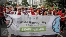 Peserta dari ISMAFARSI membentangkan spanduk saat melakukan longmarch memperingati Hari Apoteker Sedunia di kawasan Car Free Day, Jakarta, Minggu (25/9). Mereka mengajak masyarakat cerdas menggunakan obat, termasuk DaGuSiBu. (Liputan6.com/Faizal Fanani)