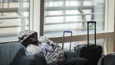 Seorang pria tidur di kursi di sebelah barang bawaannya di ruang keberangkatan bandara internasional Brussels selama pemogokan nasional di Brussels, Belgia, Senin (20/6/2022). Semua keberangkatan keluar dari bandara dibatalkan pada hari Senin setelah pemogokan nasional terhadap biaya hidup dan upah terjadi di Belgia. (AP Photo/Olivier Matthys)