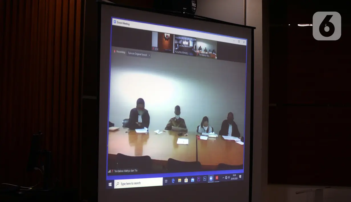 Mantan Komisioner KPU Wahyu Setiawan (kedua kiri) mendengarkan Jaksa Penutut Umum membacakan dakwaan saat sidang secara daring di Gedung KPK, Jakarta, Kamis (28/5/2020). Wahyu menjalani sidang dakwaan terkait kasus dugaan menerima suap pengurusan PAW anggota DPR dari PDIP. (merdeka.com/Dwi Narwoko)