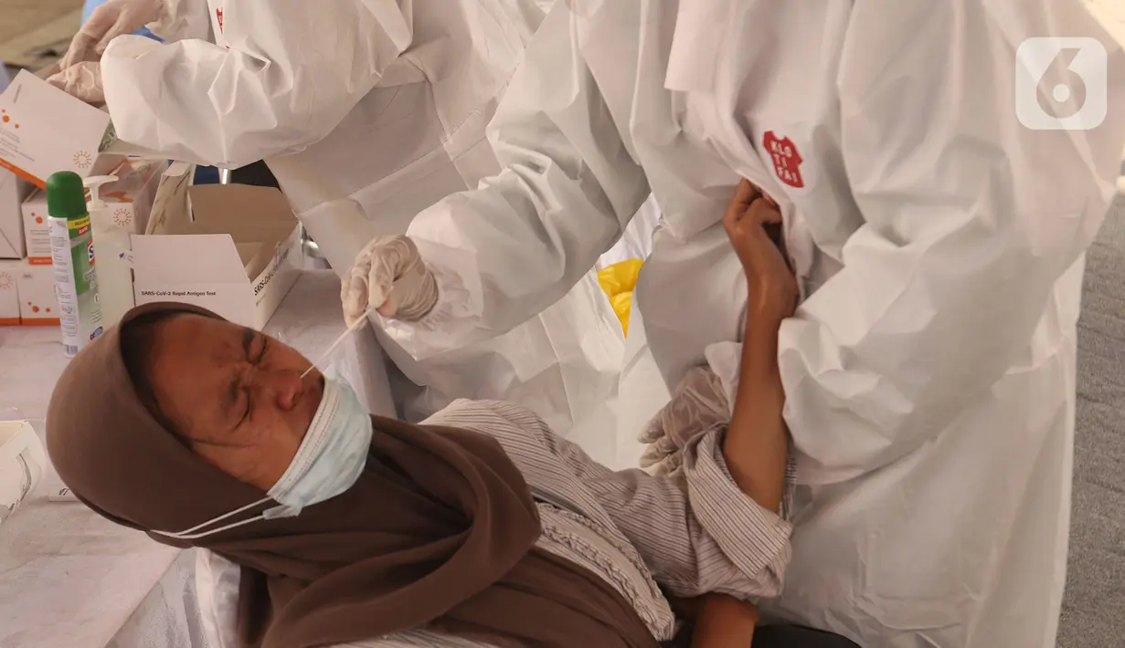 Petugas mengambil sampel lendir hidung untuk pemeriksaan tes Swab antigen kepada pengendara motor di pos pemeriksaan kesehatan, Cikarang, Sabtu (22/5/2021). Ada 14 orang dari 4.406 pengendara motor yang terindikasi positif COVID-19 pada arus balik 16-22 Mei 2021. (Liputan6.com/Herman Zakharia)