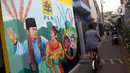 Pesepeda melintas di depan mural bertema budaya Betawi di kawasan Kampung Sentra Kreatif, RW 006 Kota Bambu Selatan, Jakarta, Rabu (3/11/2021). Pengembangan kawasan perkampungan ini bertujuan untuk mengunggah semangat masyarakat agar melestarikan budaya. (Liputan6.com/Herman Zakharia)
