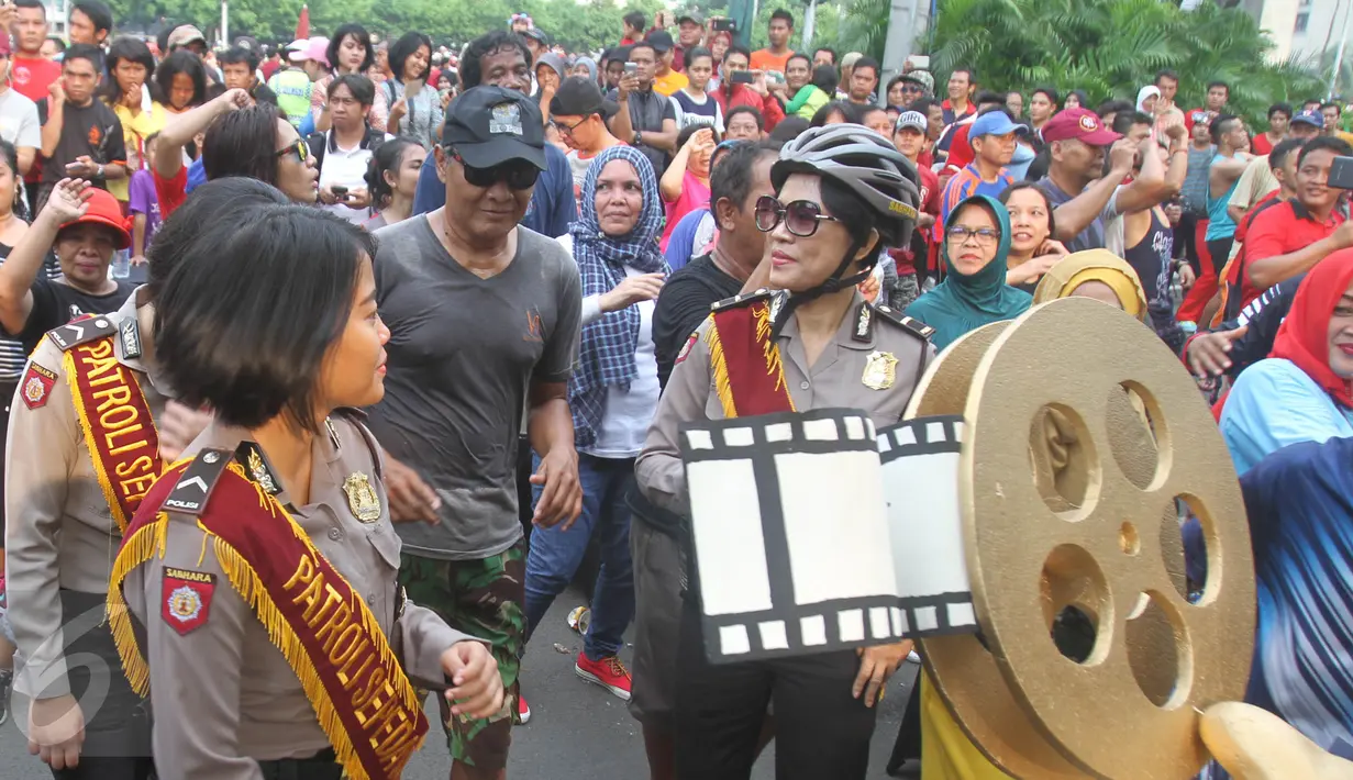 Sejumlah Polisi membawa replika rol film di Bundara HI, Jakarta, Minggu (16/4). Festival film pendek dan film animasi tentang Kepolisian bertajuk Police Movie Festival digelar dengan tema Unity and diversity. (Liputan6.com/Angga Yuniar)