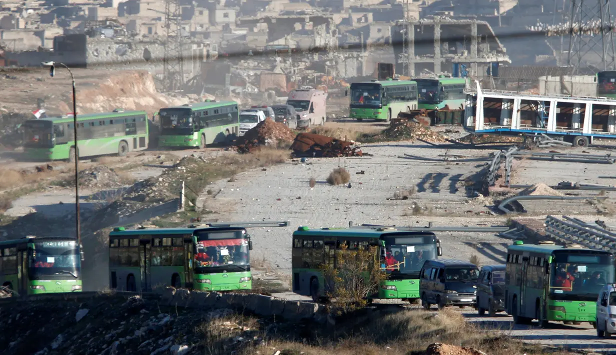 Bus dan ambulans digunakan untuk mengevakuasi ribuan warga sipil di Aleppo, Suriah, Kamis (15/12). Konflik antara pemberontak dan pasukan pemerintah yang setia kepada Presiden Suriah Basyar al Assad membuat warga harus dievakuasi. (REUTERS/Omar Sanadiki)