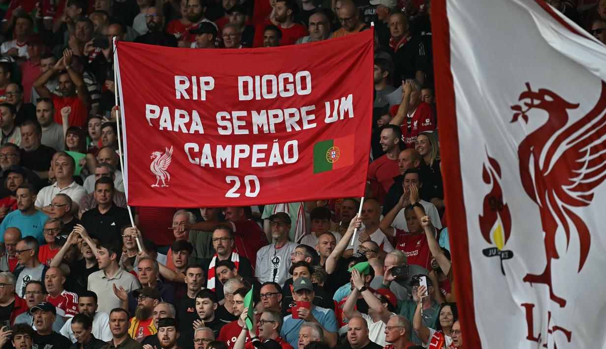 Pendukung Liverpool membentangkan spanduk untuk penghoramatan mendiang Diogo Jota saat laga Liga Inggris 2024/2025 melawan Bournemouth di Anfiled, Liverpool, Inggris, Jumat (15/08/2025) waktu setempat. (AFP/Paul Ellis)