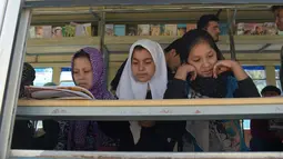 Anak-anak Afghanistan membaca buku dalam bus yang dijadikan perpustakaan keliling di Kabul, 4 April 2018. Perpustakaan keliling adalah inisiatif lulusan Oxford University, Inggris, Freshta Karim yang juga seorang pengungsi Afghanistan. (AFP/Shah MARAI)