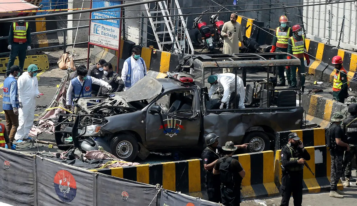 Petugas keamanan menjaga mobil van polisi yang rusak usai ledakan bom di luar tempat suci umat muslim Sufi, Lahore, Pakistan, Rabu (8/5/2019). Kebanyakan militan menganggap masjid Sufi dan ritual yang sering dilakukan di makam nabi sebagai hal 'tidak Islami.' (AP Photo/K.M. Chaudary)