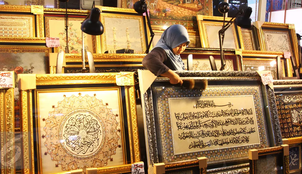 Pedagang tengah membersihkan kaligrafi di pusat perbelanjaan di Jakarta, Rabu (22/6). Selama bulan Ramadan peminat kaligrafi meningkat, sehingga para pedagang banyak meraih keuntungan. (Liputan6.com/Angga Yuniar)
