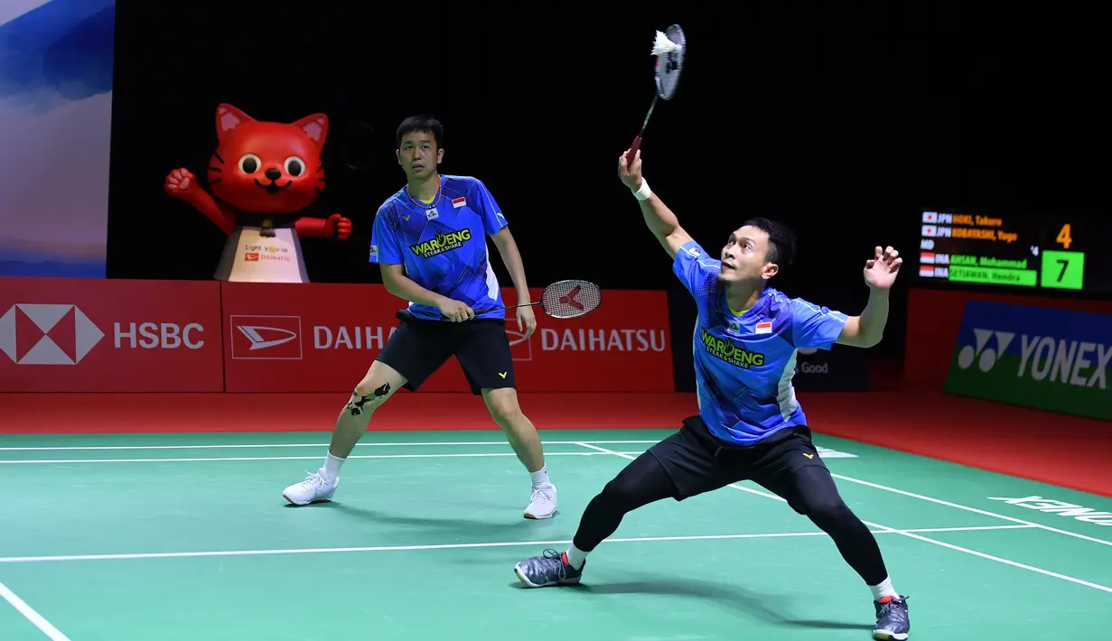 Pasangan ganda putra Indonesia, Mohammad Ahsan/Hendra Setiawan mengembalikan kok ke arah Takuro Hoki/Yugo Kobayashi (Jepang) pada babak 16 besar Indonesia Masters 2021 di Bali International Convention Centre & Westin Resort, Kamis (18/11/2021). Ahsan/Hendra kalah 21-11, 15-21, 12-21. (HUMAS PP PBSI)