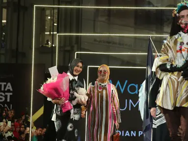 Desainer Dian Pelangi (kiri) saat tampil dalam Jakarta Modest Fashion Week di Gandaria City, Jakarta, Minggu (29/7). Dian Pelangi mengangkat tema 'Persona'. (Liputan6.com/Herman Zakharia)