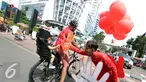 Seorang lelaki memberikan cinderamata pada bocah saat acara Car Free Day, Jakarta, Minggu (2/10) Dalam rangka menyambut Hari Cuci Tangan Sedunia, Lifebouy memberikan pengetahuan mengenai pentingnya cuci tangan. (Liputan6.com/Helmi Afandi)