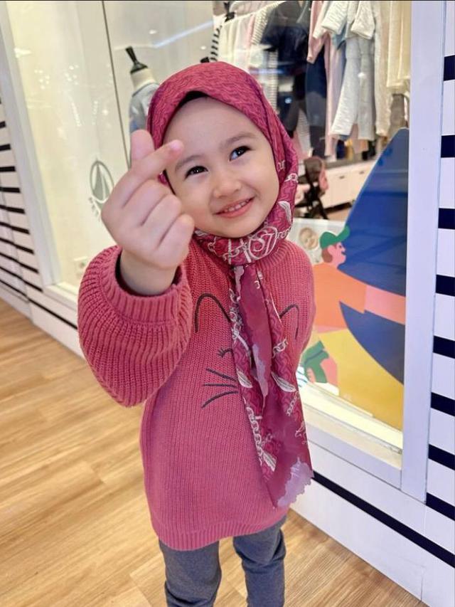 Khalisa Putri kenakan hijab warna pink dengan berpose love ala Korea