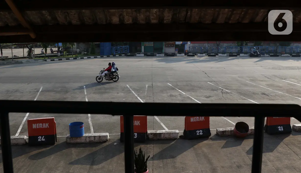 Pengendara motor melintasi Terminal Bus AKAP Kampung Rambutan, Jakarta, Kamis (7/5/2020). Meski Menhub Budi Karya Sumadi mengijinkan kembali seluruh moda transportasi beroperasi kembali namun aktivitas di terminal bus AKAP Kampung Rambutan masih terlihat kosong. (Liputan6.com/Helmi Fithriansyah)