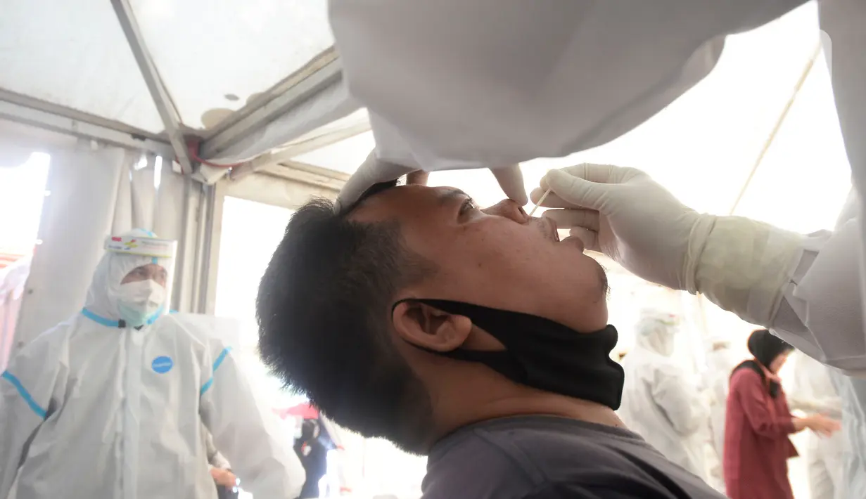 Petugas medis mengambil sempel lendir salah satu peserta test SWAB massal gratis di halaman Dinas Kesehatan Tangeramg Selatan, Banten, Minggu (30/8/2020). Test Swab gratis tersebut diikuti 750 orang untuk pencegahaan penyebaran Covid-19. (merdeka.com/Dwi Narwoko)