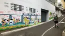 Warga melintas di depan mural dan akses khusus pejalan kaki di Jalan Darul Maarif, Jakarta Selatan, Rabu (11/3/2020). PT MRT Jakarta berkolaborasi dengan ITDP menata jalan-jalan sekitar stasiun untuk meningkatkan aksesibilitas warga sekitar. (Liputan6.com/Immanuel Antonius)