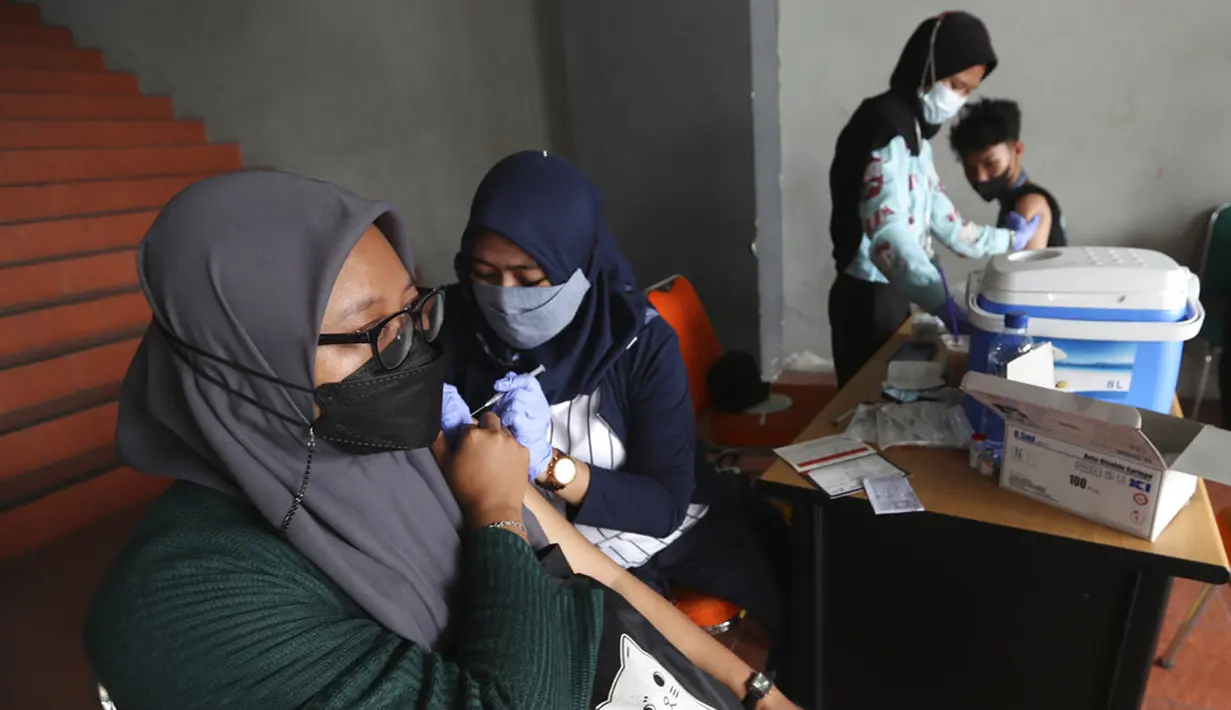 Warga menerima suntikan vaksin virus corona COVID-19 Sinovac di Stadion Patriot Candrabhaga, Bekasi, Kamis (28/10/2021). Indonesia melihat ke depan dengan waspada akan gelombang ketiga COVID-19 selama perjalanan liburan yang akan datang. (AP Photo/Achmad Ibrahim)
