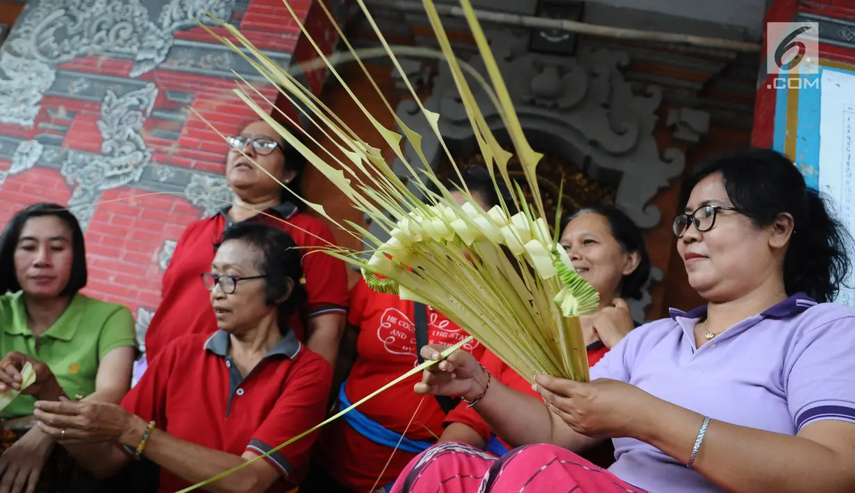Sejumlah ibu serati banten mempersiapkan Gebogan yang akan digunakan dalam upacara Mecaru dalam menyambut perayaan hari Raya Nyepi dan Tahun baru Saka 1941 di Pura Tribhuana Agung Sukmajaya Depok, Jawa Barat, Selasa (5/3). (Liputan6.com/Herman Zakharia)