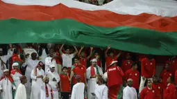 Para pendukung Oman membentangkan bendera raksasa saat Timnas Oman menghadapi Kirgistan pada laga ketiga Grup F Piala Asia 2023 di Abdullah bin Khalifa Stadium, Doha, Qatar, Kamis (25/1/2024). (AFP/Karim Jaafar)