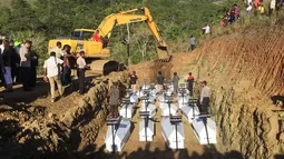 Pemakaman massal korban banjir bandang di Sentani, Kabupaten Jayapura, Papua, Rabu (27/3). Prosesi pemakaman dihadiri oleh sejumlah pejabat dan tokoh masyarakat di Provinsi Papua.  (NETHY DHARMA SOMBA/AFP)