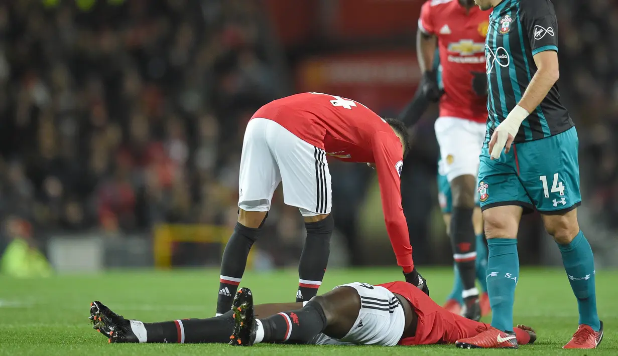 Pemain Manchester United, Romelu Lukaku terbaring usai benturan dikepala saat melawan Southampton pada lanjutan Premier League di Old Trafford, Manchester, (30/12/2017). MU hanya bermain imbang 0-0.  (AFP/Oli Scarff)