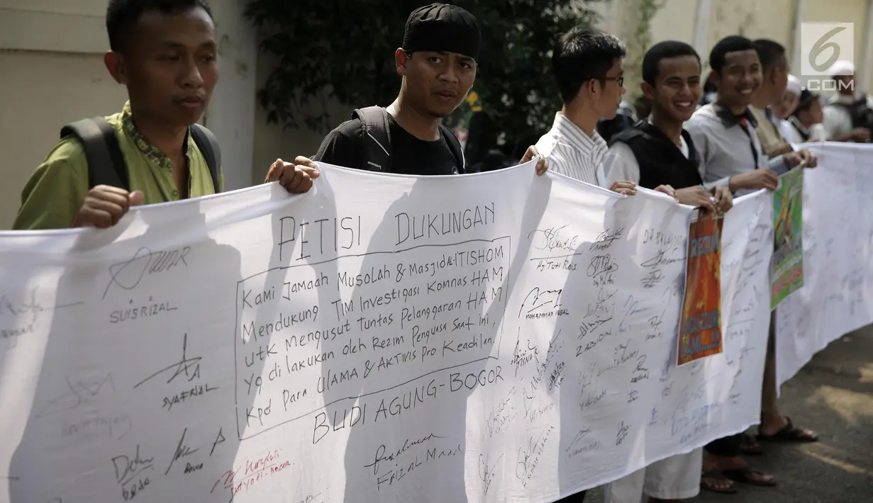 Massa alumni 212 membentangkan spanduk Aksi Galang Petisi Tolak Kriminalisasi Ulama di kantor Komnas HAM, Jakarta, Jumat (19/5). Para alumni 212 mengumpulkan satu juta tanda tangan sebagai bentuk dukungan terhadap Komnas HAM. (Liputan6.com/Faizal Fanani)