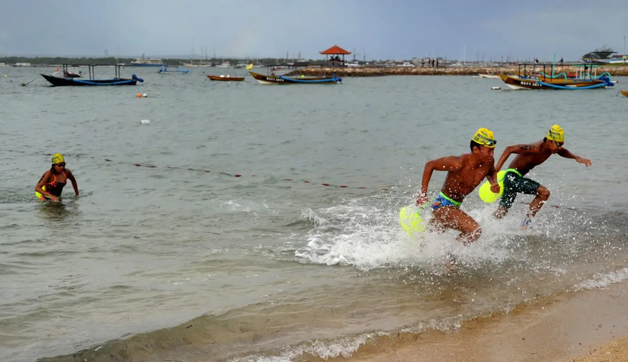 Peserta berlomba ke garis finish dalam kompetisi renang Oceanman Bali 2021 di sebuah pantai di Sanur, Denpasar, Bali, Sabtu (18/9/2021). Oceanman Bali 2021 merupakan salah satu bagian dari seri dunia Oceanman. (SONY TUMBELAKA/AFP)