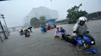 Sejumlah pengendara motor terpaksa mendorong kendaraannya akibat nekat menerobos banjir yang menggenangi jalan Gunung Sahari, Jakarta, Senin (9/2/2015).  (Liputan6.com/Faizal Fanani)