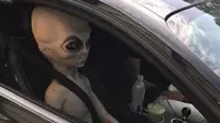 Pengemudi membawa boneka alien.
