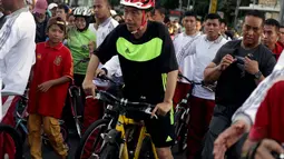 Presiden RI, Joko Widodo bersepeda di Hari Bebas Kendaraan Bermotor di kawasan Bundaran Hotel Indonesia, Minggu (11/1/2015). Kawalan ketat pasukan pengaman Presiden mengiringi aktivitas Jokowi bersepeda. (Liputan6.com/Faizal Fanani)