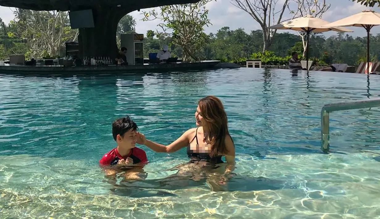 Perempuan yang kini berusia 44 tahun ini tampak sedang bermain di kolam dangkal bersama sang buah hati, Kenzou. (Liputan6.com/IG/@tamarableszynskiofficial)