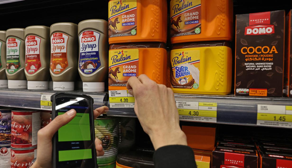 Seorang pekerja memperbarui harga produk ke dolar AS, di Beirut pada 1 Maret 2023 karena krisis politik dan ekonomi di negara itu tidak menunjukkan tanda-tanda mereda. Di supermarket di Beirut, karyawan bekerja dengan cepat menempelkan label harga terbaru di rak. (Photo by Joseph EID / AFP)