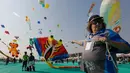 Seorang peserta dari Australia menerbangkan layang-layang saat festival layang-layang internasional di Ahmadabad, India (7/1). Dalam festival ini layang-layang dari berbagai negara menghiasi langit Ahmadabad, India. (AP Photo/Ajit Solanki)
