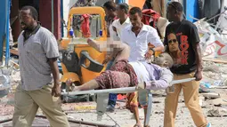 Petugas membawa korban dari serangan bom mobil di Mogadishu, Somalia, Rabu (25/1). Orang-orang yang terluka saat ini dilaporkan tengah mendapat perawatan di rumah sakit Hayad, yang terdekat dengan lokasi kejadian. (AP Photo)
