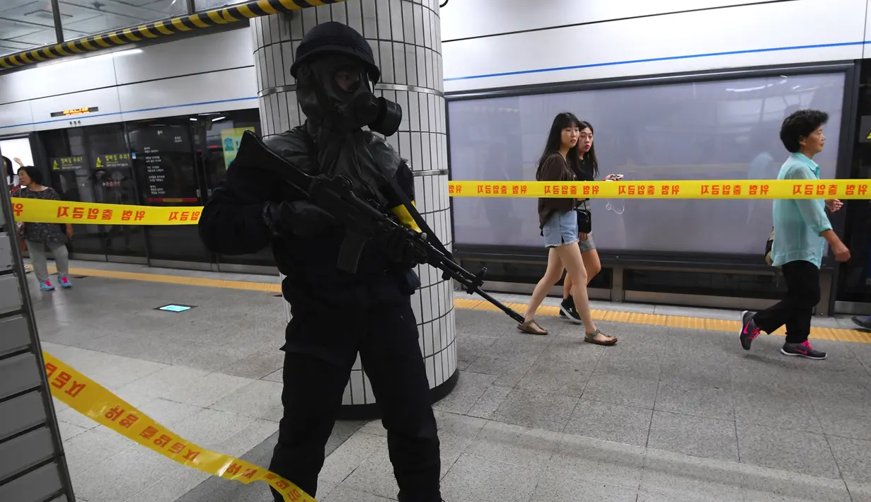 Polisi Korea Selatan berjaga saat latihan anti-teror di sebuah stasiun kereta bawah tanah di Seoul (22/8).  Puluhan ribu tentara Korea Selatan dan AS ikut serta dalam latihan militer gabungan "Ulchi Freedom Guardian. (AFP Photo/Jung Yeon-Je)
