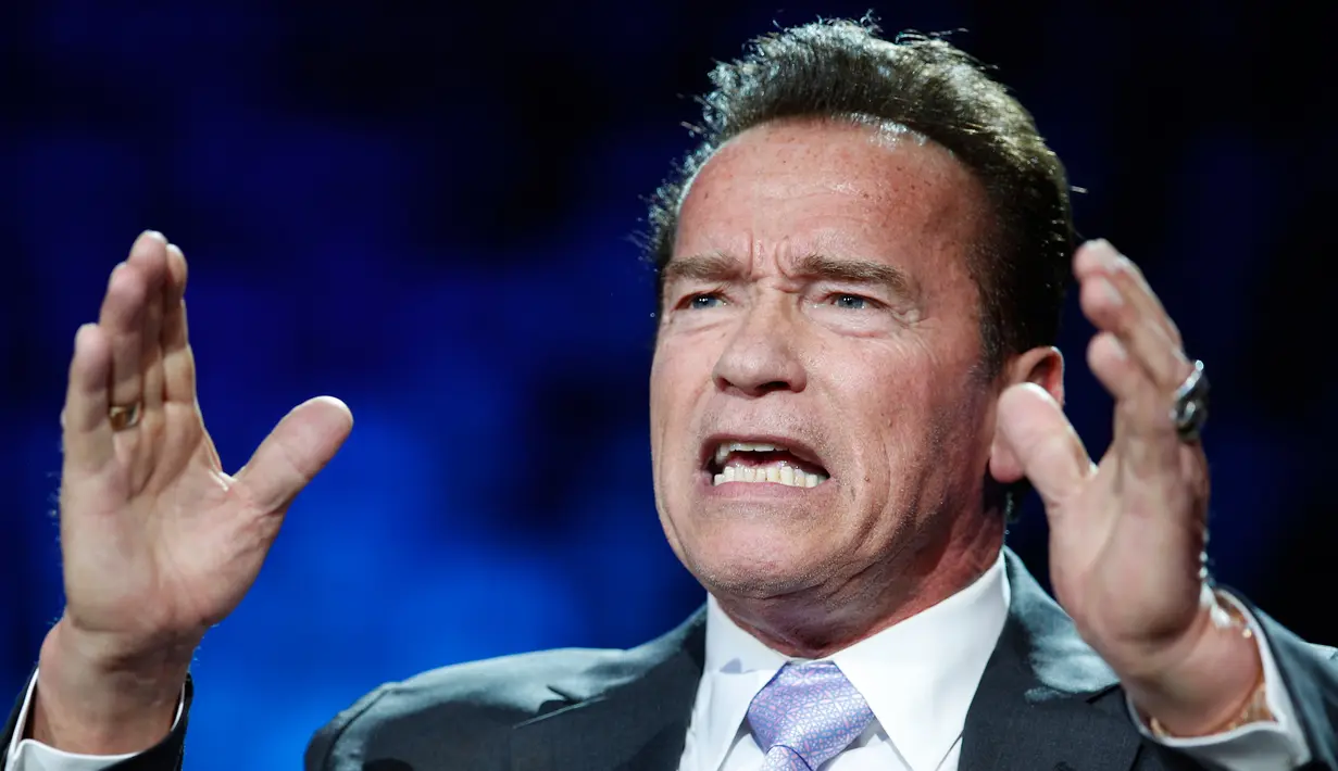 Aktor AS, Arnold Schwarzenegger berbicara pada forum KTT One Planet Summit di Paris, Selasa (12/12). Mantan Gubernur California itu mencuri perhatian dengan dua cincin di jari yang salah satunya bermotif tengkorak warna perak. (AP Photo/Christophe Ena)