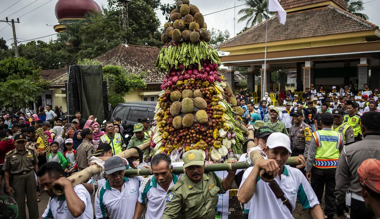 Para peserta mengarak tumpeng durian selama festival Kenduren di Jombang, Jawa Timur, Minggu (3/3). Festival tersebut merupakan acara tahunan yang digelar setiap memasuki musim panen durian sebagai bentuk syukur petani kepada Tuhan (Juni Kriswanto/AFP)