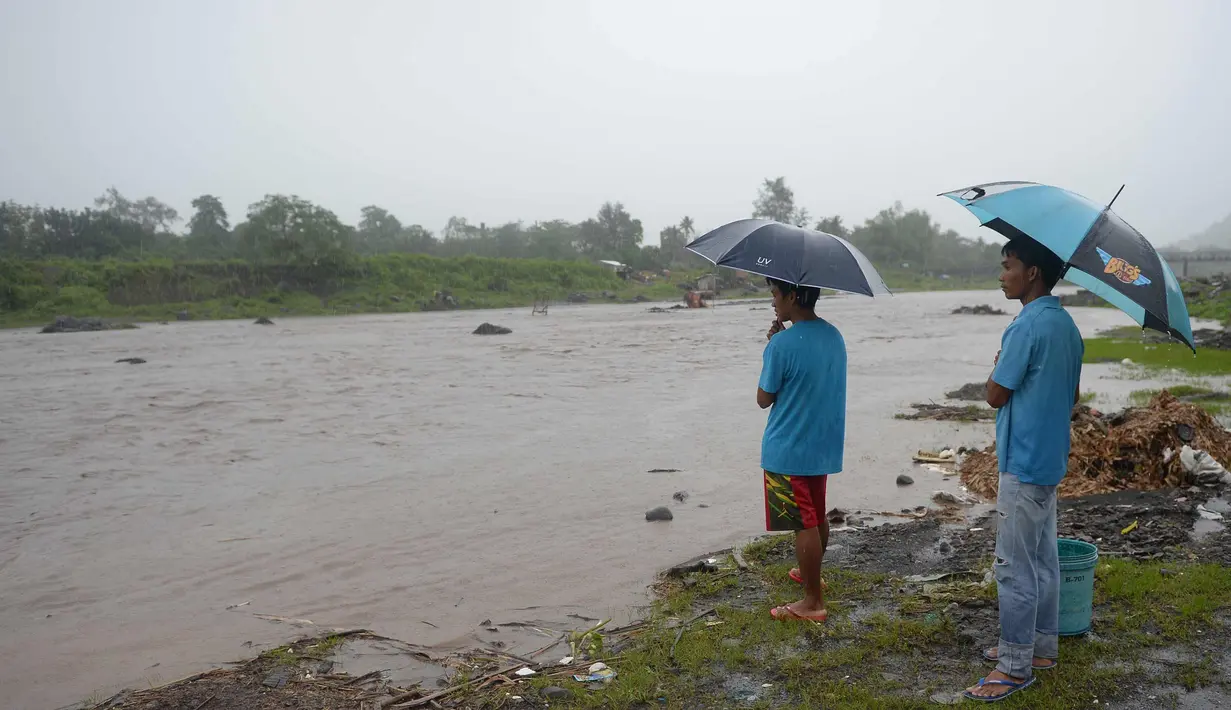Warga melihat arus sungai di dekat gunung berapi Mayon di kota Daraga, provinsi Albay, selatan Manila (27/1). Pihak berwenang telah memperingatkan warga untuk menghindari sungai yang dapat mengancam masyarakat sekitar. (AFP Photo/Ted Aljibe)