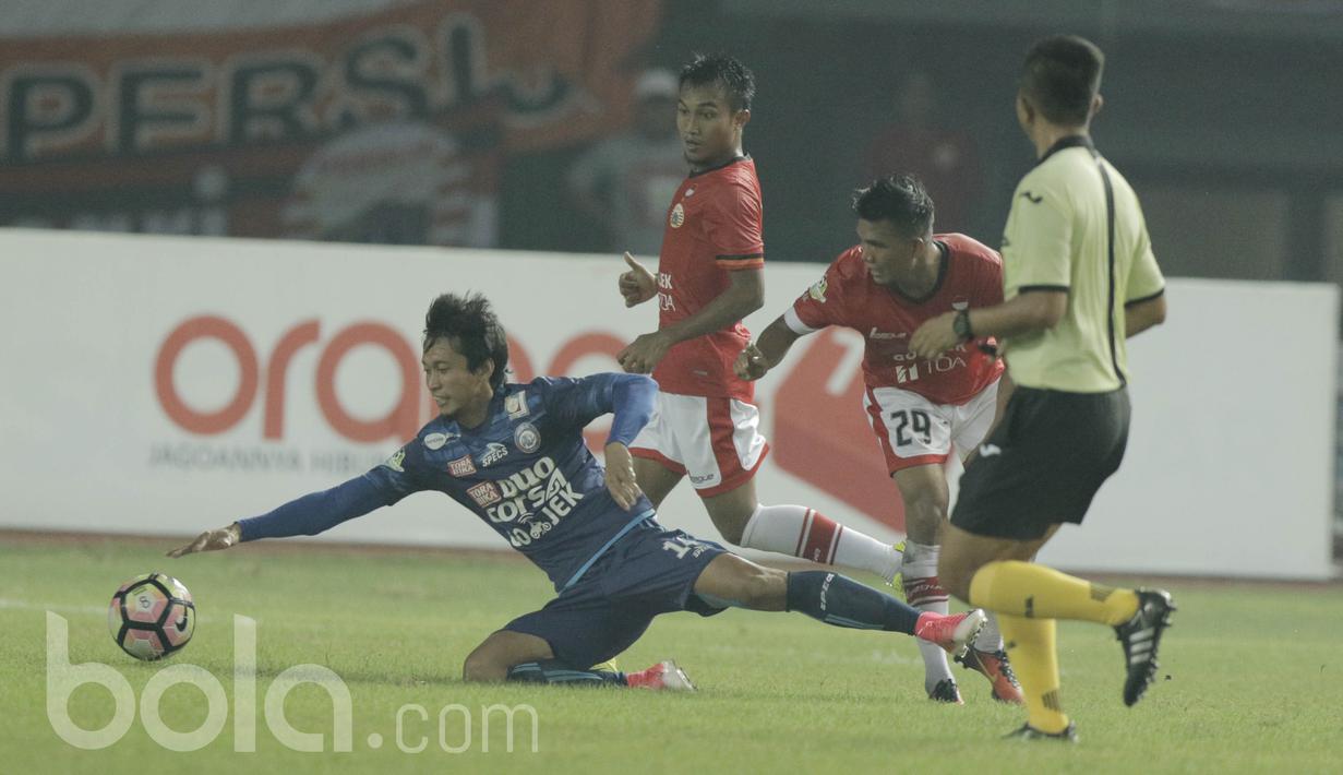 Pemain Arema, Arif Suyono, terjatuh saat berebut bola dengan pemain Persija, Sandi Suthe pada laga lanjutan liga 1 Indonesia di Stadion Patriot, Bekasi, Jumat (02/06/2017). Persija Menang 2-0. (Bola.com/M Iqbal Ichsan)