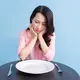 Potret seorang perempuan menahan lapar setelah mengonsumsi makanan dietnya. (Foto dok: Freepik/timeimage).