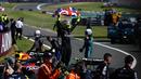 Pembalap Mercedes, Lewis Hamilton membentangkan benedera Inggris saat merayakan kemenangan di Formula 1 GP Inggris 2024 yang berlangsung di Sirkuit Silverstone, Inggris, Minggu (08/07/2024). (AFP/Benjamin Cremel)