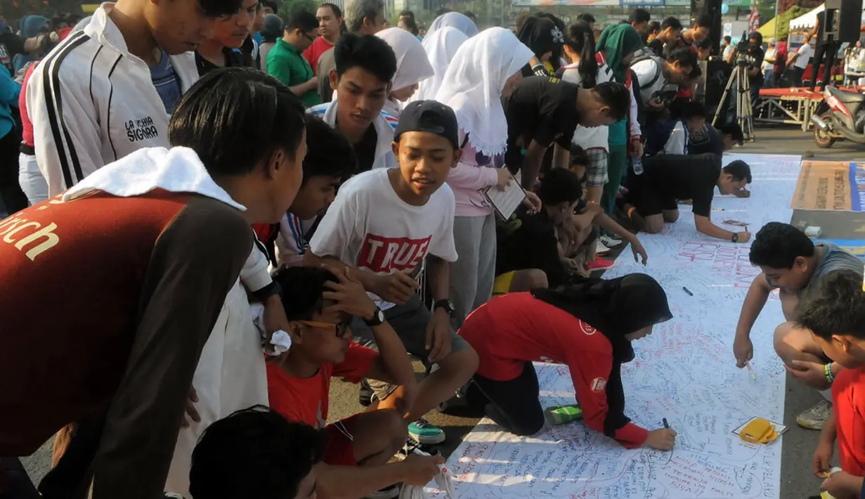 Sejumlah warga antusias menorehkan pesan dalam 'Aksi Damai 5.000 Tandatangan Suarakan Hak-hak Sipil dan Anak-Perempuan' di Jakarta, (24/8/2014), (Liputan6.com/Herman Zakharia)