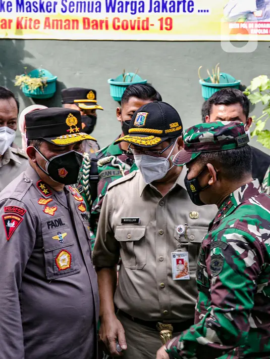 Pangdam Jaya Mayjen TNI Dudung Abdurrachman (kanan) dan Kapolda Metro Jaya Irjen Pol Fadil Imran (kiri) saat membagikan masker ke warga di Sunter Muara, Tanjung Priok, Jakarta, Selasa (9/2/2021). Kegiatan ini untuk menyadarkan masyarakat akan pentingnya penggunaan masker. (Liputan6.com/FaizalFanani)