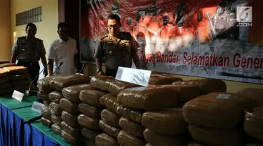 Kabid Humas Polda Metro Jaya Kombes Pol Argo Yuwono melihat barang bukti 225 kg ganja saat rilis di RS Polri Kramat Jati Jakarta, Rabu (30/8). Satresnarkoba Polda Metro Jaya menggagalkan peredaran 225 kg ganja asal Aceh. (Liputan6.com/Helmi Fithriansyah)