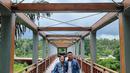 Wanita usia 40 tahun dan suaminya tampak mengenakan baju yang senada sambil tersenyum berfoto di jembatan iconic di Ubud yaitu The Four Season Sayan. (Instagram/therealdisastr)